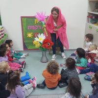 ציפי, מחנכת בכיתת הבוגרים ממחיזה את שיר הרקפת מהספר מר סביון וגברת רקפת, מעון נעמת השיטה ביבנה